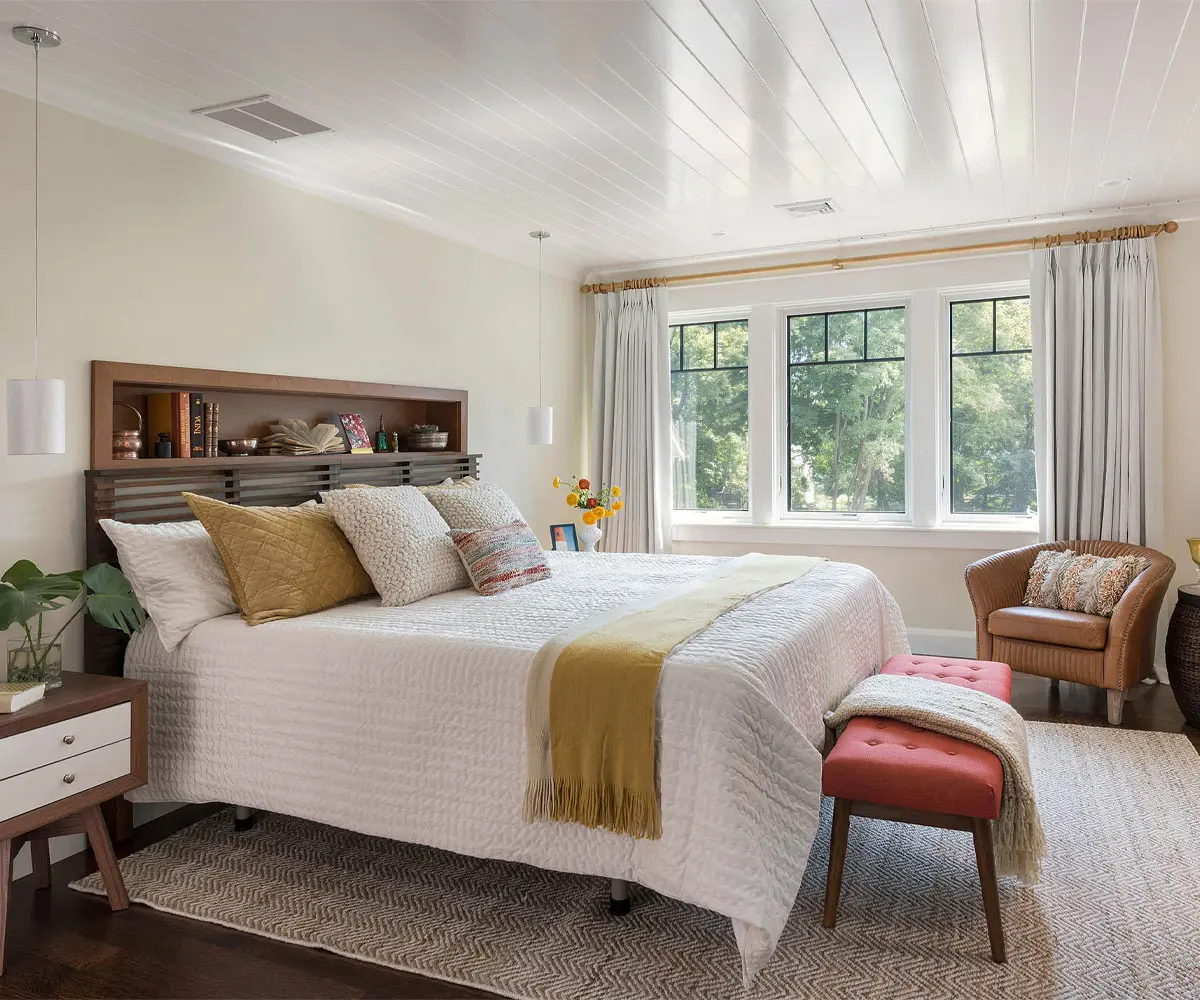 Bright bedroom with three new black-framed windows above the bed, the kind of comfort a winter window replacement brings to a Minnesota home.