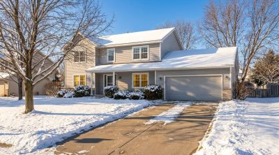 Two-story Lakeville MN home on a sunny winter morning with snow on the lawn and new white windows, a good example of winter window replacement in Minnesota.
